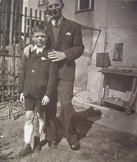 With his dad during the war in Dvořákova Street. In the background you can see a garbage trash.
