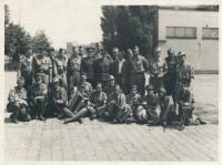Stanislav Husa – skupina barikádníků na Nákladovém nádraží Žižkov (v první řadě druhý z prava, sedící), dobová fotografie, 9. května 1945