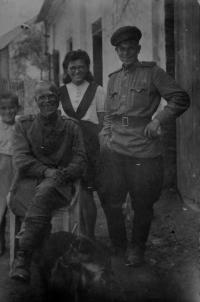 Irena Ondruchová, bratranec Luboš Adámek a pes Alík s ruskými vojáky ve Výškovicích / květen 1945