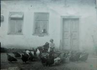 Sister Marie Holatková feeds the hen in 1938 in front of the family farm in the village of Frankov