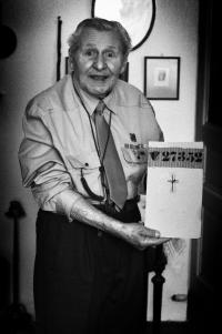 František Wretzl dnes. V rukou drží své vězeňské číslo z koncetračního tábora. 2011.