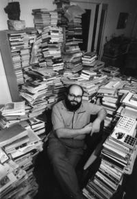 Kornel in their apartment surrounded with books