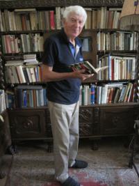 Ladislav Lašek at his library and with a book by the most beloved author - Karel Čapek