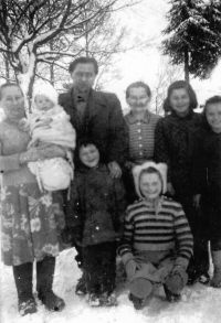 Vlasta Tkadlecová (dole v pruhovaném svetru) s bratrem, babičkou (stojící nad ní), strýcem, tetou a dalšími příbuznými / konec 50. let